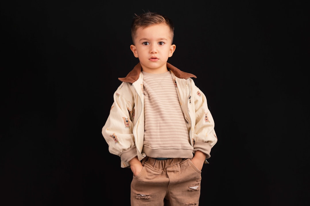 young-boy-in-stylish-outfit-stands-against-black-background-gwxssjth4ye